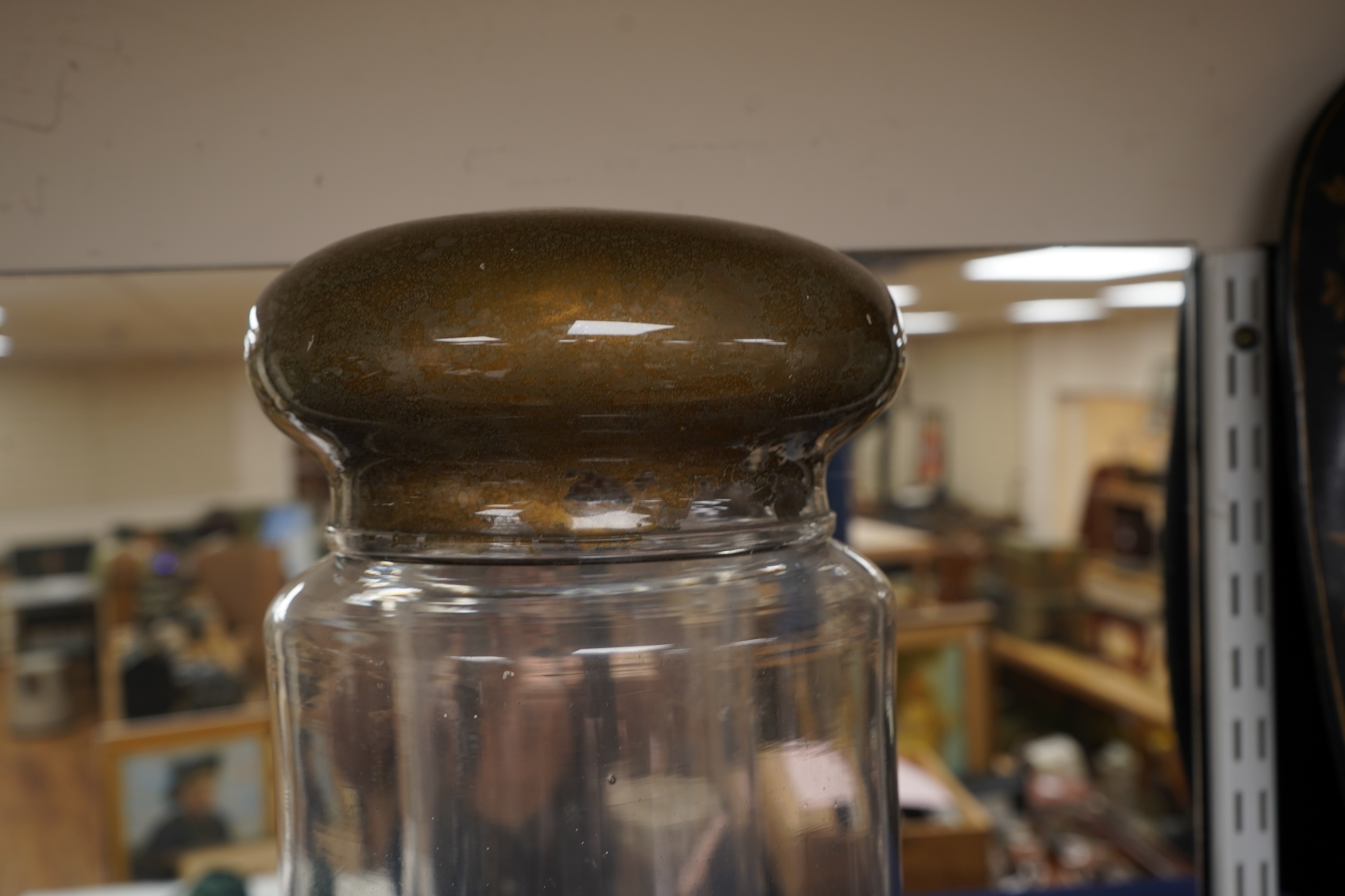 An 18th century cylindrical glass drug jar with remnants of gilding to the lid, 42cm high